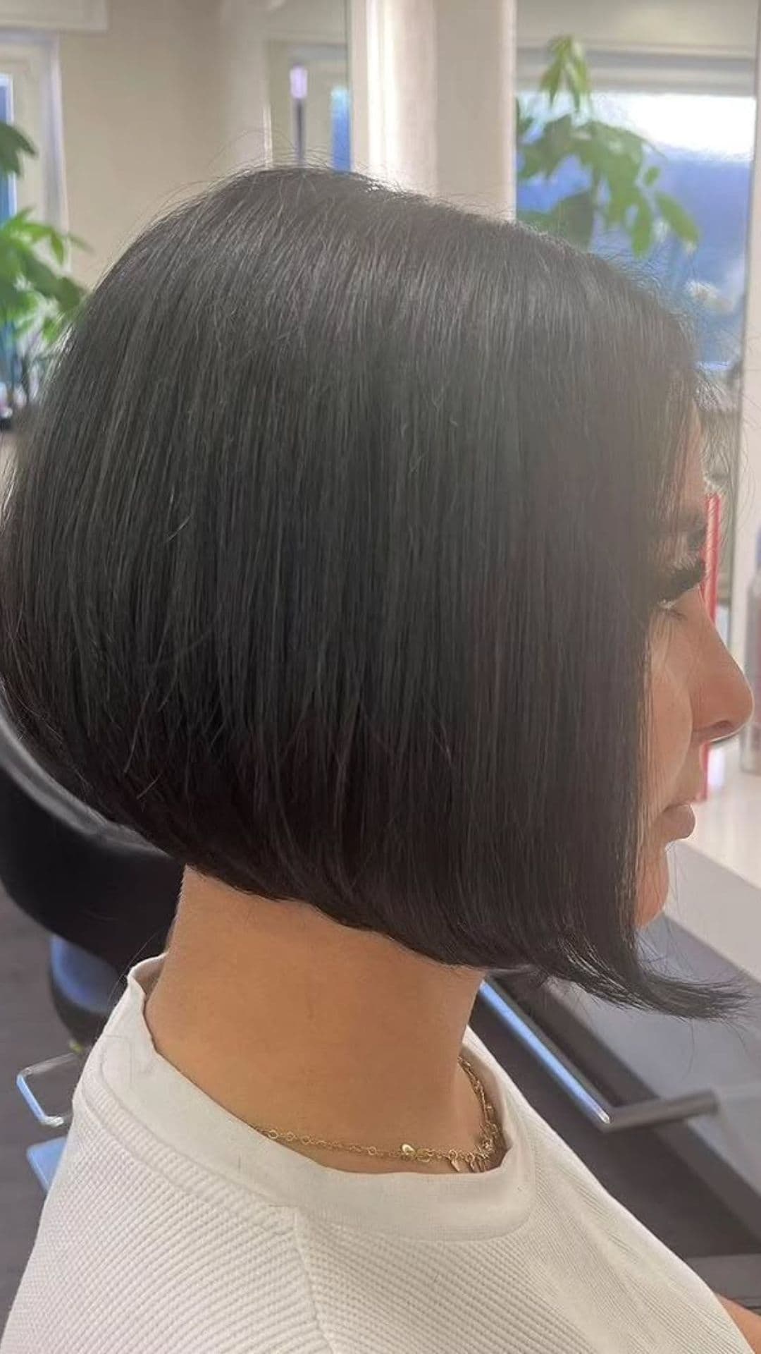 A woman with a round face modelling a Short Stacked Bob hairstyle.