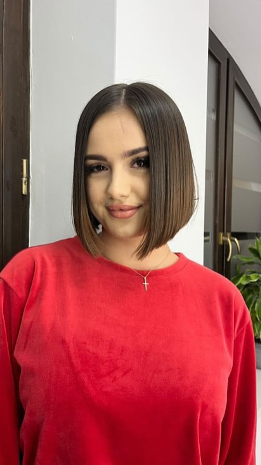 A woman with a round face modelling a Sleek Straight Bob hairstyle.