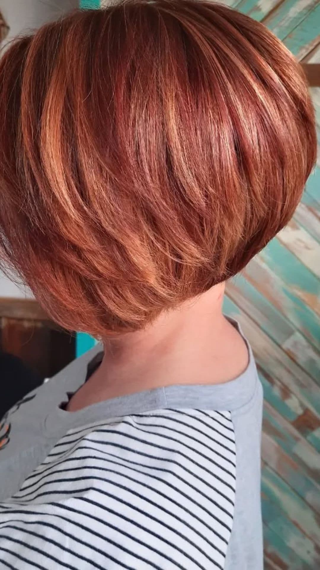 A woman with a round face modelling a Stacked Bob with Layers hairstyle.